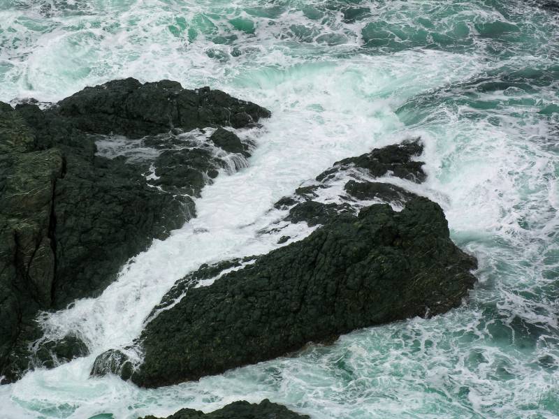 AroundNL-25 The sea foams on the rocks 300 feet below the Long Point lighthouse in Twillingate